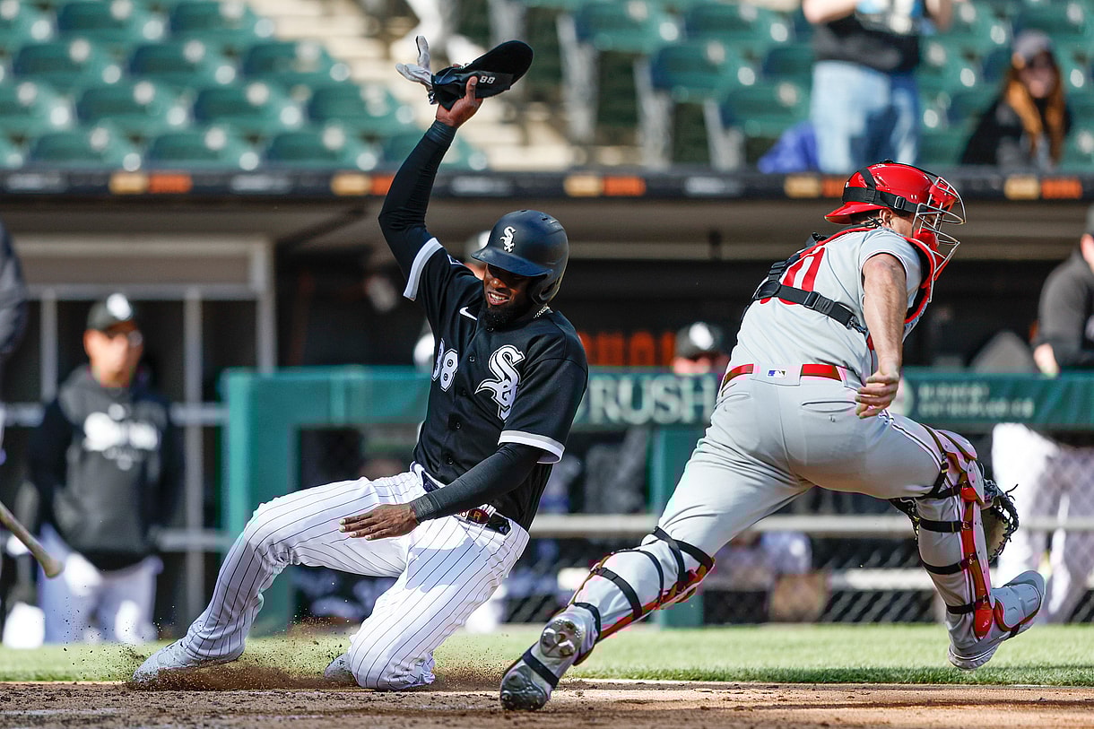 Apr 18, 2023; Chicago, Illinois, USA; Chicago White Sox center fielder Luis Robert Jr. (88) scores against Philadelphia Phillies catcher J.T. Realmuto (10) during the third inning of game one of the doubleheader at Guaranteed Rate Field. Mandatory Credit: Kamil Krzaczynski-Imagn Images