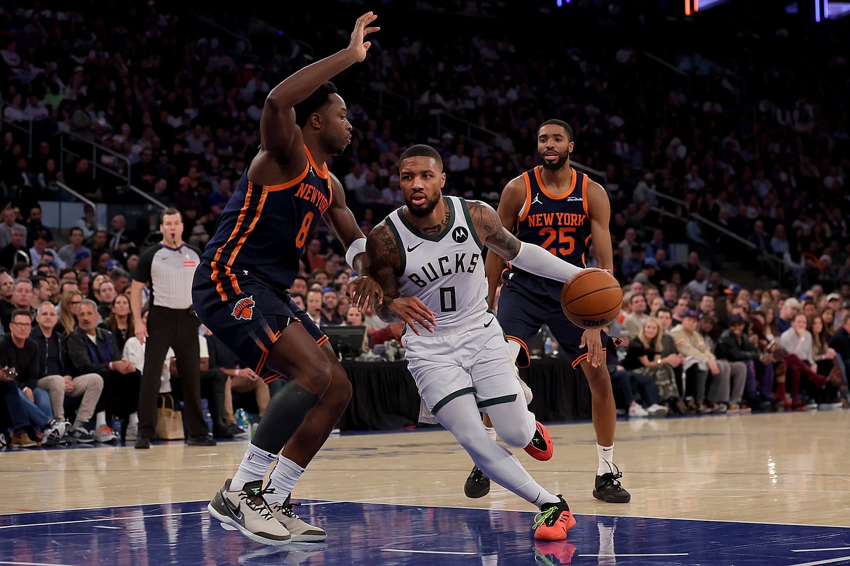 Nov 8, 2024; New York, New York, USA; Milwaukee Bucks guard Damian Lillard (0) drives to the basket against New York Knicks forwards OG Anunoby (8) and Mikal Bridges (25) during the second quarter at Madison Square Garden. Mandatory Credit: Brad Penner-Imagn Images