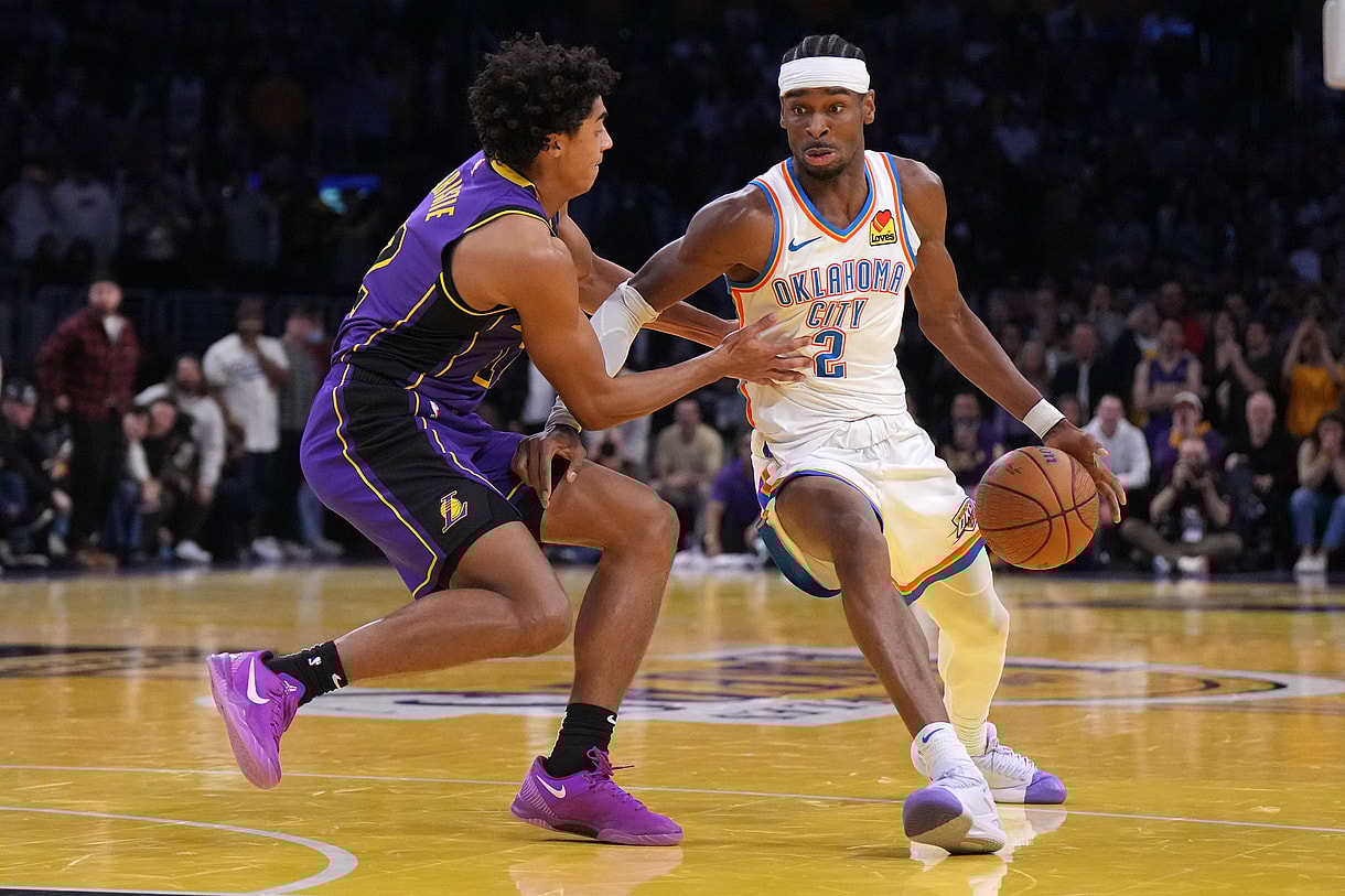 Nov 29, 2024; Los Angeles, California, USA; Oklahoma City Thunder guard Shai Gilgeous-Alexander (2) dribbles against Los Angeles Lakers guard Austin Reaves (15) in the second half at Crypto.com Arena. Mandatory Credit: Kirby Lee-Imagn Images