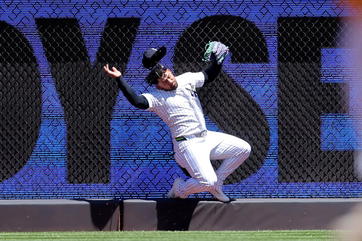 Jasson Dominguez makes a catch at the wall for the Yankees against the Rangers