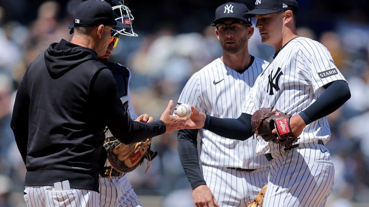 Brendan Beck handing the ball to Aaron Boone for the Yankees