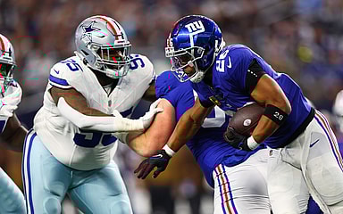 New York Giants running back Saquon Barkley (26) runs with the ball as Dallas Cowboys defensive tackle Johnathan Hankins (95) defends during the first quarter at AT&T Stadium