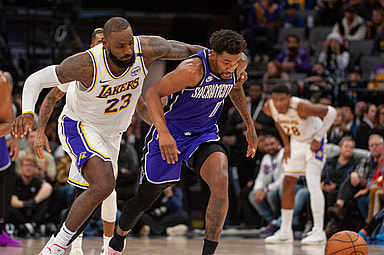Dec 21, 2024; Sacramento, California, USA; Los Angeles Lakers forward LeBron James (23) and Sacramento Kings guard Malik Monk (0) fight for possession of the ball during the fourth quarter at Golden 1 Center. Mandatory Credit: Ed Szczepanski-Imagn Images