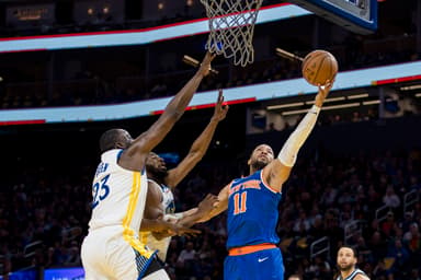 New York Knicks guard Jalen Brunson (11) shoots as Golden State Warriors center Draymond Green (23) and forward Andrew Wiggins (22) defend during the first half at Chase Center