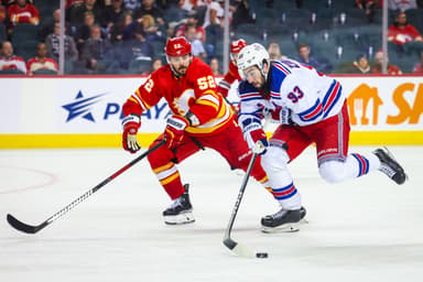 Oct 24, 2023; Calgary, Alberta, CAN; New York Rangers center Mika Zibanejad (93) and Calgary Flames defenseman MacKenzie Weegar (52) battle for the puck during the third period at Scotiabank Saddledome. Mandatory Credit: Sergei Belski-USA TODAY Sports