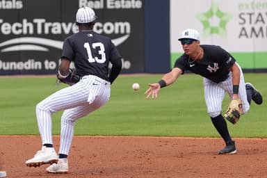 Mar 1, 2025; Tampa, Florida, USA; New York Yankees shortstop Anthony Volpe (11) tosses a ball to third base Jazz Chisholm Jr. (13)  to make a double play during the third inning at George M. Steinbrenner Field. Mandatory Credit: Dave Nelson-Imagn Images