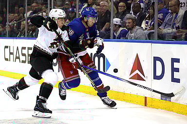 Arizona Coyotes defenseman Travis Dermott (33) and New York Rangers left wing Will Cuylle (50) fight for the puck during the second period at Madison Square Garden