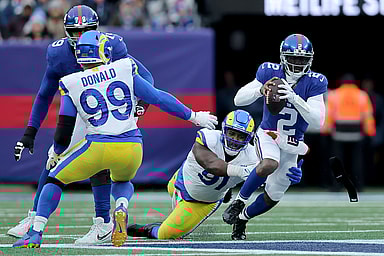 New York Giants quarterback Tyrod Taylor (2) is sacked by Los Angeles Rams defensive tackles Kobie Turner (91) and Aaron Donald (99) during the third quarter at MetLife Stadium