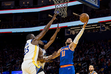New York Knicks guard Jalen Brunson (11) shoots as Golden State Warriors center Draymond Green (23) and forward Andrew Wiggins (22) defend during the first half at Chase Center