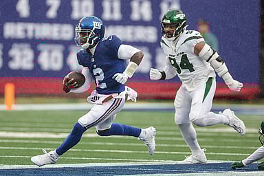 New York Giants quarterback Tyrod Taylor (2) carries the ball in front of New York Jets defensive end Solomon Thomas (94) during the first half at MetLife Stadium