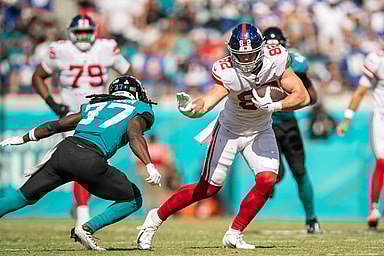Oct 23, 2022; Jacksonville, Florida, USA;  New York Giants tight end Daniel Bellinger (82) catches the ball against Jacksonville Jaguars cornerback Tre Herndon (37) in the second quarter at TIAA Bank Field. Mandatory Credit: Jeremy Reper-USA TODAY Sports