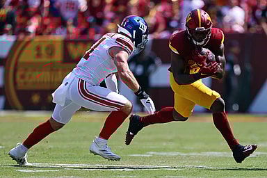 Sep 15, 2024; Landover, Maryland, USA; Washington Commanders running back Brian Robinson Jr. (8) runs the ball against New York Giants linebacker Micah McFadden (41) during the first quarter at Commanders Field. Mandatory Credit: Peter Casey-Imagn Images