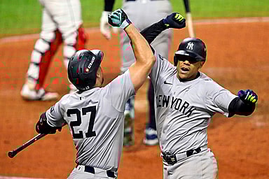 Oct 19, 2024; Cleveland, Ohio, USA; New York Yankees outfielder Juan Soto (22) celebrates with designated hitter Giancarlo Stanton (27) after hitting a three run home run during the tenth inning against the Cleveland Guardians during game five of the ALCS for the 2024 MLB playoffs at Progressive Field. Mandatory Credit: David Richard-Imagn Images