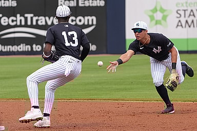 Mar 1, 2025; Tampa, Florida, USA; New York Yankees shortstop Anthony Volpe (11) tosses a ball to third base Jazz Chisholm Jr. (13)  to make a double play during the third inning at George M. Steinbrenner Field. Mandatory Credit: Dave Nelson-Imagn Images