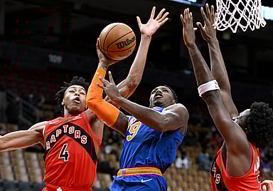 New York Knicks guard RJ Barrett (9) tries to shoot the ball as Toronto Raptors forwards Scottie Barnes (4) and OG Anunoby (3) defend in the first half at Scotiabank Arena