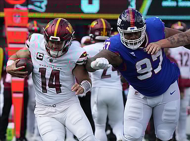 Sam Howell of the Commanders is chased by Dexter Lawrence of the Giants in the first half. The NY Giants host the Washington Commanders at MetLife Stadium in East Rutherford