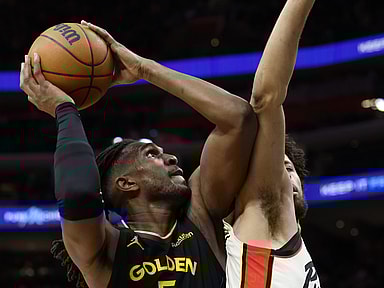 Jan 9, 2025; Detroit, Michigan, USA;  Golden State Warriors forward Kevon Looney (5) shoots against Detroit Pistons guard Cade Cunningham (2) in the second half at Little Caesars Arena. Mandatory Credit: Rick Osentoski-Imagn Images