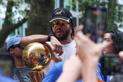 Jalen Brunson holding the championship trophy for the Knicks