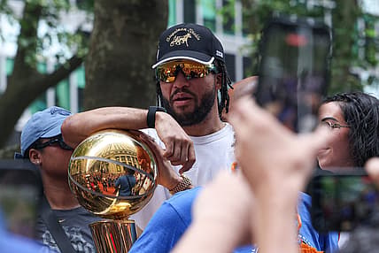 Jalen Brunson holding the championship trophy for the Knicks