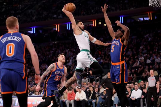 Feb 24, 2024; New York, New York, USA; Boston Celtics forward Jayson Tatum (0) drives to the basket against New York Knicks forward Precious Achiuwa (5) and center Isaiah Hartenstein (55) and guard Donte DiVincenzo (0) during the first quarter at Madison Square Garden. Mandatory Credit: Brad Penner-USA TODAY Sports
