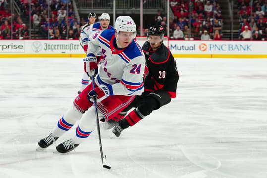 May 11, 2024; Raleigh, North Carolina, USA; New York Rangers right wing Kaapo Kakko (24) skates with the puck against Carolina Hurricanes center Sebastian Aho (20) during the second period in game four of the second round of the 2024 Stanley Cup Playoffs at PNC Arena. Mandatory Credit: James Guillory-USA TODAY Sports