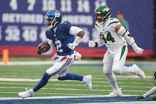 New York Giants quarterback Tyrod Taylor (2) carries the ball in front of New York Jets defensive end Solomon Thomas (94) during the first half at MetLife Stadium