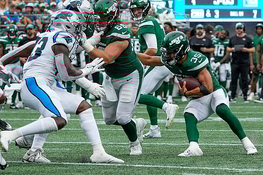 New York Jets running back Travis Dye (35) follows the block by center Joe Tippmann (66) during the second half against the Carolina Panthers at Bank of America Stadium