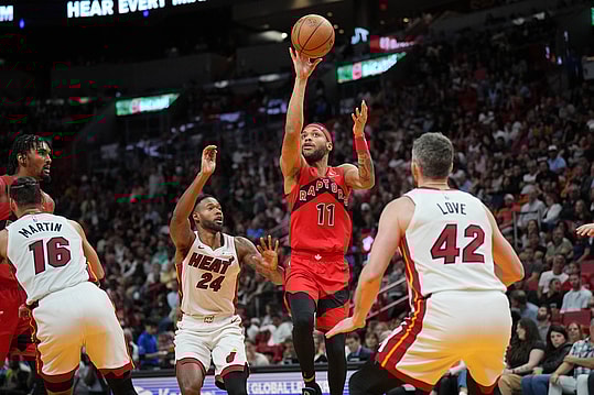 Apr 12, 2024; Miami, Florida, USA;  Toronto Raptors forward Bruce Brown (11) lobs a pass toward the basket as Miami Heat forward Haywood Highsmith (24) and forward Kevin Love (42) defend during the second half at Kaseya Center. Mandatory Credit: Jim Rassol-USA TODAY Sports