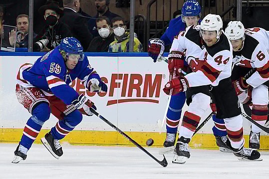 Sep 29, 2022; New York, New York, USA; New Jersey Devils left wing Miles Wood (44) makes a pass while defended by New York Rangers center Karl Henriksson (59) during the first period at Madison Square Garden. Mandatory Credit: Dennis Schneidler-USA TODAY Sports