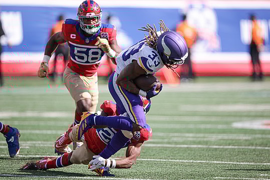 Sep 8, 2024; East Rutherford, New Jersey, USA; Minnesota Vikings running back Aaron Jones (33) fights for yards as New York Giants cornerback Dru Phillips (22) tackles during the second half at MetLife Stadium. Mandatory Credit: Vincent Carchietta-Imagn Images