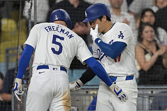 Aug 5, 2024; Los Angeles, California, USA; Los Angeles Dodgers designated hitter Shohei Ohtani (17) talks with first baseman Freddie Freeman (5) after hitting a solo home run in the eighth inning against the Philadelphia Phillies at Dodger Stadium. Mandatory Credit: Jayne Kamin-Oncea-Imagn Images