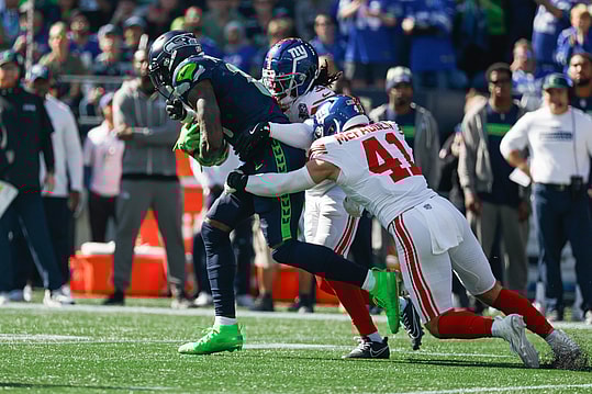 Oct 6, 2024; Seattle, Washington, USA; Seattle Seahawks wide receiver DK Metcalf (14) runs for yards after the catch against New York Giants cornerback Deonte Banks (3) and linebacker Micah McFadden (41) during the first quarter at Lumen Field. Mandatory Credit: Joe Nicholson-Imagn Images