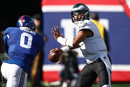 Oct 20, 2024; East Rutherford, New Jersey, USA; Philadelphia Eagles quarterback Jalen Hurts (1) throws the ball as New York Giants linebacker Brian Burns (0) pursues during the second half at MetLife Stadium. Mandatory Credit: Vincent Carchietta-Imagn Images