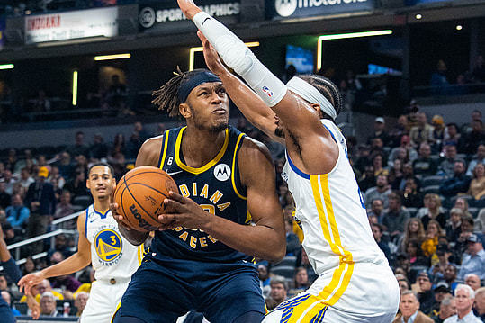 Dec 14, 2022; Indianapolis, Indiana, USA; Indiana Pacers center Myles Turner (33) drives against Golden State Warriors guard Moses Moody (4) in the second half at Gainbridge Fieldhouse. Mandatory Credit: Trevor Ruszkowski-Imagn Images
