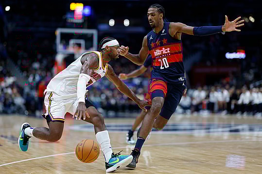Nov 4, 2024; Washington, District of Columbia, USA; Golden State Warriors guard Buddy Hield (7) drives to the basket as Washington Wizards forward Alexandre Sarr (20) defends in the second half at Capital One Arena. Mandatory Credit: Geoff Burke-Imagn Images