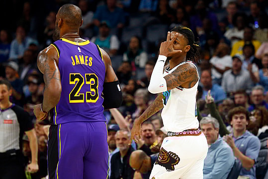 Nov 6, 2024; Memphis, Tennessee, USA; Memphis Grizzlies guard Ja Morant (12) reacts toward Los Angeles Lakers forward LeBron James (23) after a three point basket during the first half at FedExForum. Mandatory Credit: Petre Thomas-Imagn Images