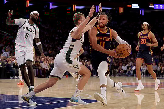 Nov 8, 2024; New York, New York, USA; New York Knicks guard Jalen Brunson (11) drives to the basket against Milwaukee Bucks guard AJ Green (20) and forward Bobby Portis (9) during the third quarter at Madison Square Garden. Mandatory Credit: Brad Penner-Imagn Images