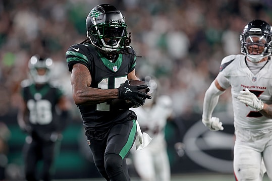 Oct 31, 2024; East Rutherford, New Jersey, USA; New York Jets wide receiver Davante Adams (17) runs with the ball for a touchdown against Houston Texans safety Jalen Pitre (5) during the fourth quarter at MetLife Stadium. Mandatory Credit: Brad Penner-Imagn Images