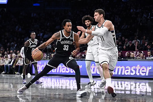 Dec 8, 2024; Brooklyn, New York, USA; Brooklyn Nets center Nic Claxton (33) drives to the basket while being defended by Milwaukee Bucks center Brook Lopez (11) during the first half at Barclays Center. Mandatory Credit: John Jones-Imagn Images