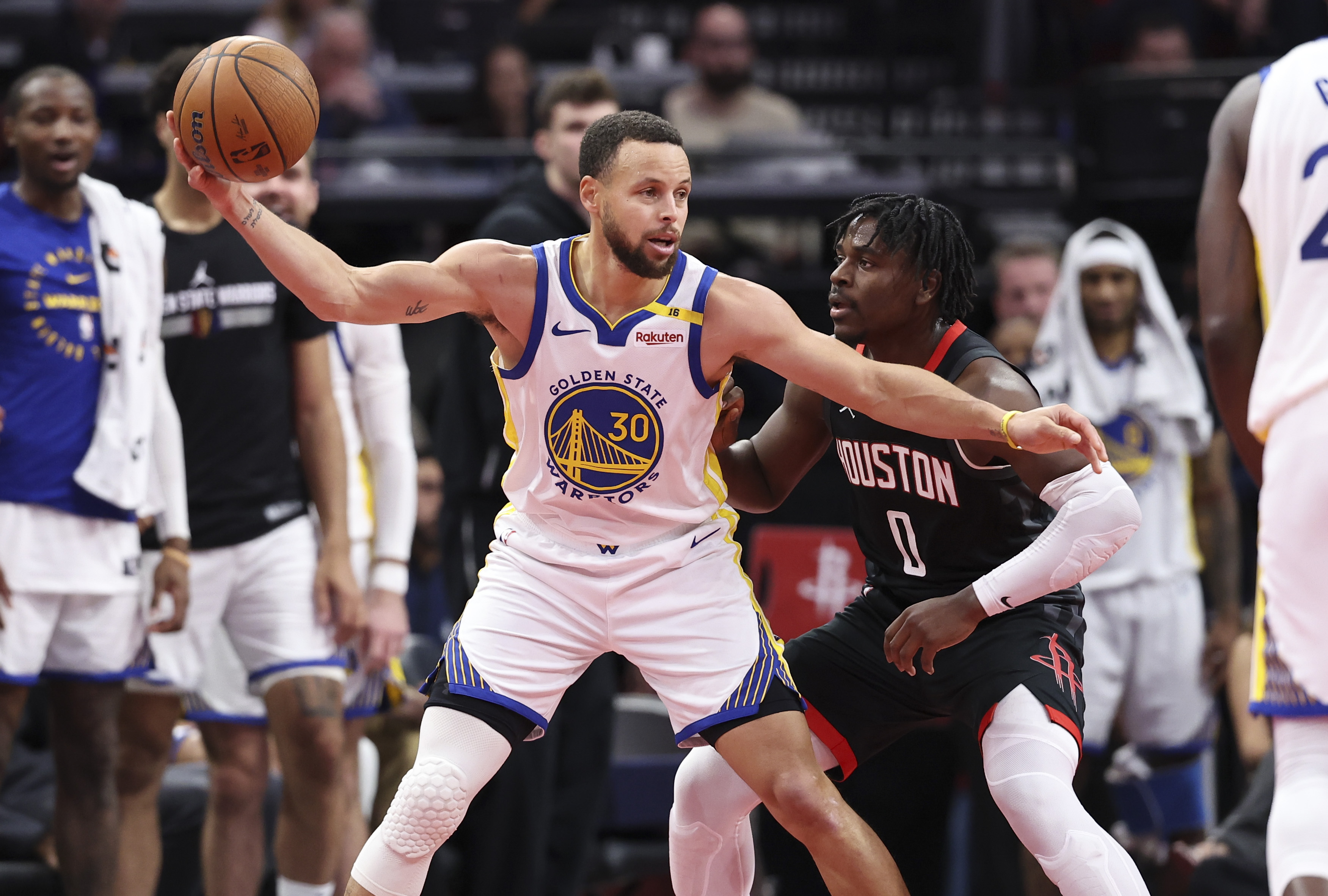 Dec 11, 2024; Houston, Texas, USA; Golden State Warriors guard Stephen Curry (30) controls the ball as Houston Rockets guard Aaron Holiday (0) defends during the fourth quarter at Toyota Center. Mandatory Credit: Troy Taormina-Imagn Images