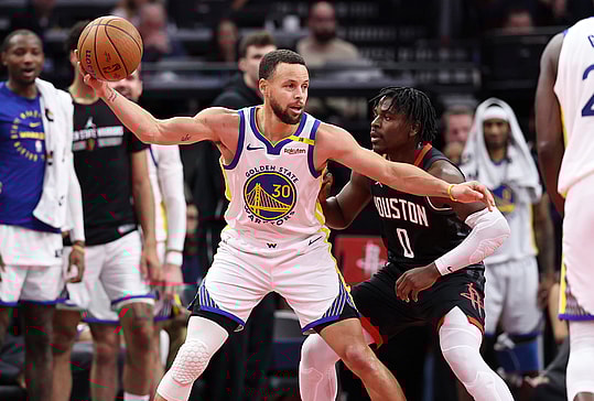Dec 11, 2024; Houston, Texas, USA; Golden State Warriors guard Stephen Curry (30) controls the ball as Houston Rockets guard Aaron Holiday (0) defends during the fourth quarter at Toyota Center. Mandatory Credit: Troy Taormina-Imagn Images