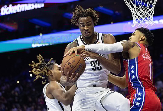 Nov 22, 2024; Philadelphia, Pennsylvania, USA; Brooklyn Nets center Nic Claxton (33) grabs a rebound past Philadelphia 76ers forward KJ Martin (1) during the fourth quarter at Wells Fargo Center. Mandatory Credit: Bill Streicher-Imagn Images