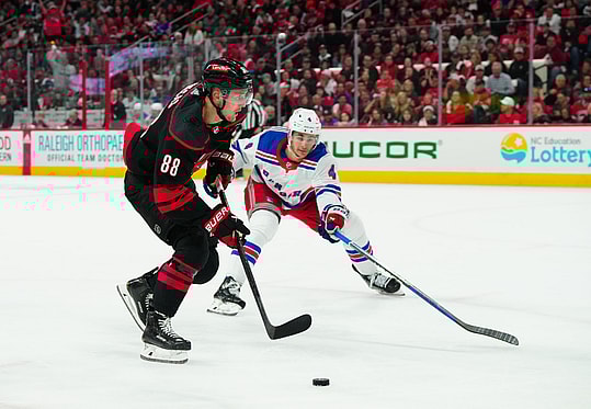 May 9, 2024; Raleigh, North Carolina, USA; Carolina Hurricanes center Martin Necas (88) skates with the puck past New York Rangers defenseman Braden Schneider (4) during the first period in game three of the second round of the 2024 Stanley Cup Playoffs at PNC Arena. Mandatory Credit: James Guillory-USA TODAY Sports