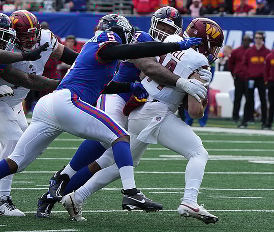 Dexter Lawrence and Kayvon Thibodeaux of the Giants sack Sam Howell of the Commanders in the first half. The NY Giants host the Washington Commanders at MetLife Stadium