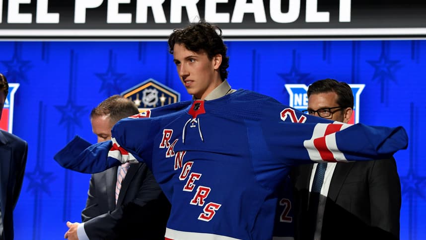 New York Rangers draft pick Gabriel Perreault puts on his sweater after being selected with the twenty third pick in round one of the 2023 NHL Draft at Bridgestone Arena