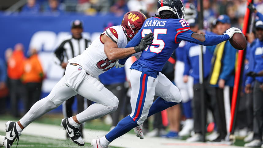 New York Giants cornerback Deonte Banks (25) is pushed out of bounds by Washington Commanders tight end Logan Thomas (82) after an interception during the first half at MetLife Stadium