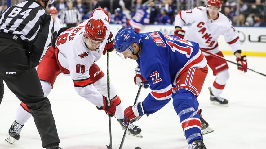 Carolina Hurricanes center Martin Necas (88) and New York Rangers center Nick Bonino (12) battle for the puck during a face-off in the third period at Madison Square Garden