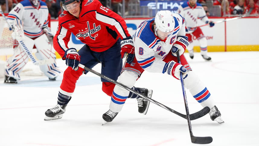 New York Rangers defenseman Jacob Trouba (8) skates with the puck as Washington Capitals left wing Sonny Milano (15) defends during the first period at Capital One Arena