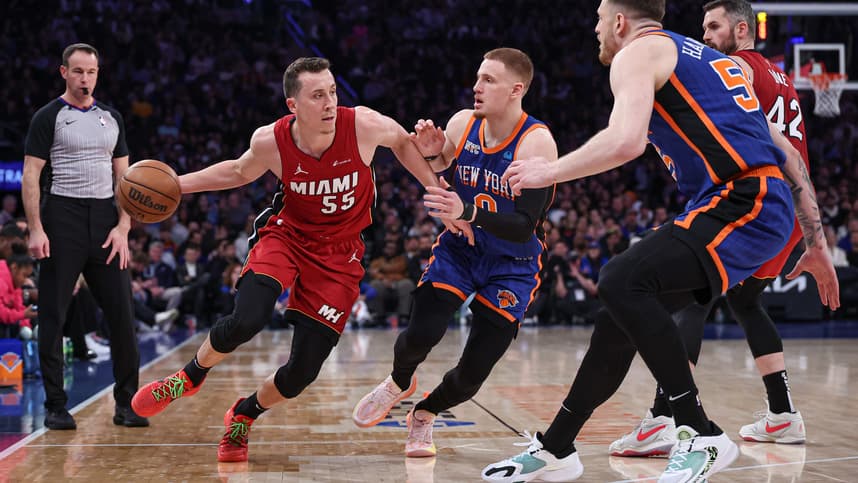 Miami Heat forward Duncan Robinson (55) dribbles against New York Knicks guard Donte DiVincenzo (0) and center Isaiah Hartenstein (55) during the first half at Madison Square Garden
