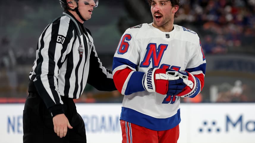 New York Rangers center Vincent Trocheck (16) is led off the ice by linesman Libor Suchanek (60) after a roughing call against Trochek and New York Islanders defenseman Alexander Romanov (not pictured) during the third period of a Stadium Series ice hockey game at MetLife Stadium
